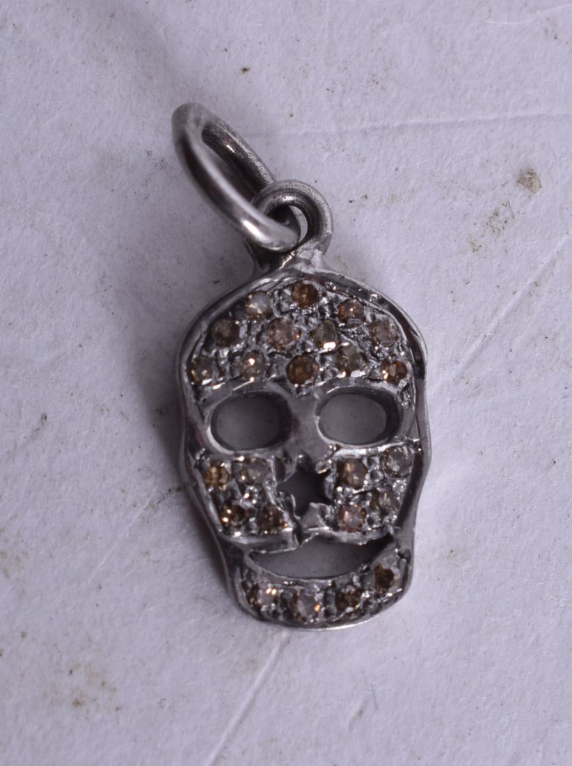 A Diamond Chip Skull Pendant. 1.7cm x 0.8 cm, weight 0.9g: A Diamond Chip Skull Pendant. 1.7cm x 0.8 cm, weight 0.9g