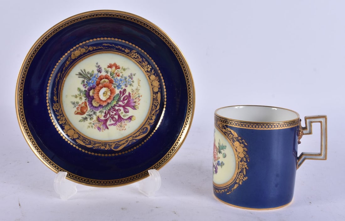 A GERMAN MEISSEN PORCELAIN CUP AND SAUCER painted with flowers. 12 cm wide. (2): A GERMAN MEISSEN PORCELAIN CUP AND SAUCER painted with flowers. 12 cm wide. (2)