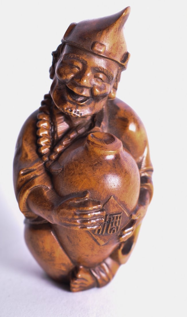 A Carved Seated Man holding an Urn 7.9cm x 4cm x 4cm, weight 45g: A Carved Seated Man holding an Urn 7.9cm x 4cm x 4cm, weight 45g