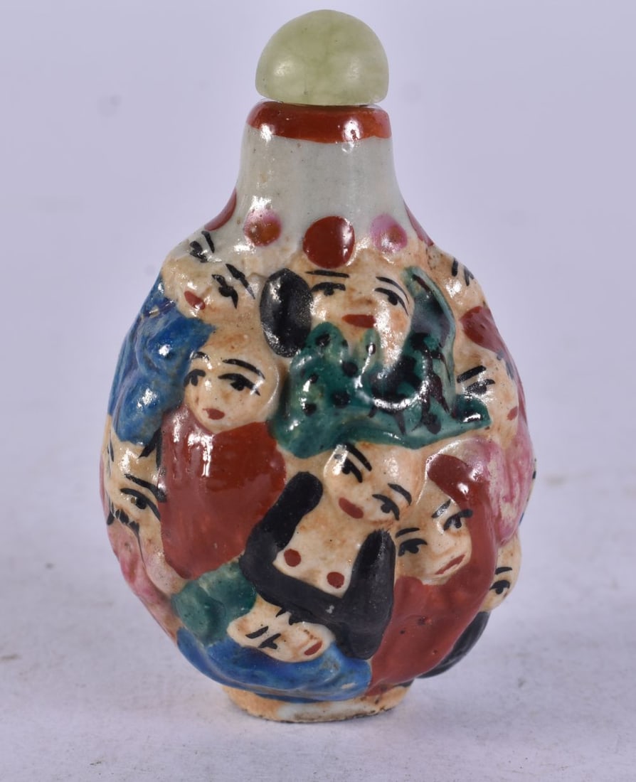 A Moulded Snuff Bottle decorated with Faces. 6.7cm x 4.2cm x 3.5cm, weight 30g: A Moulded Snuff Bottle decorated with Faces. 6.7cm x 4.2cm x 3.5cm, weight 30g