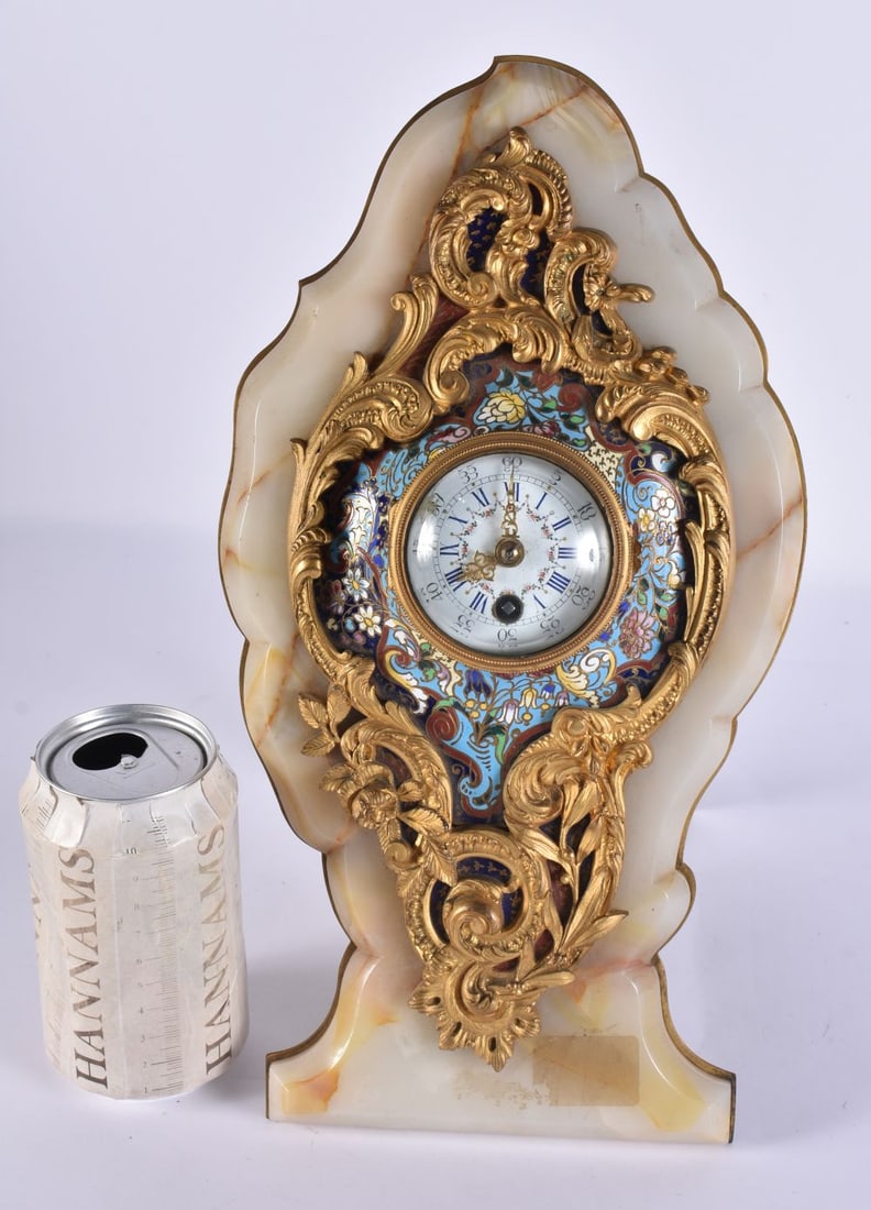 A 19TH CENTURY FRENCH ONYX, ORMOLU AND CHAMPLEVE ENAMEL STRUT CLOCK decorated with foliage. 32 cm x (1 of 7)
