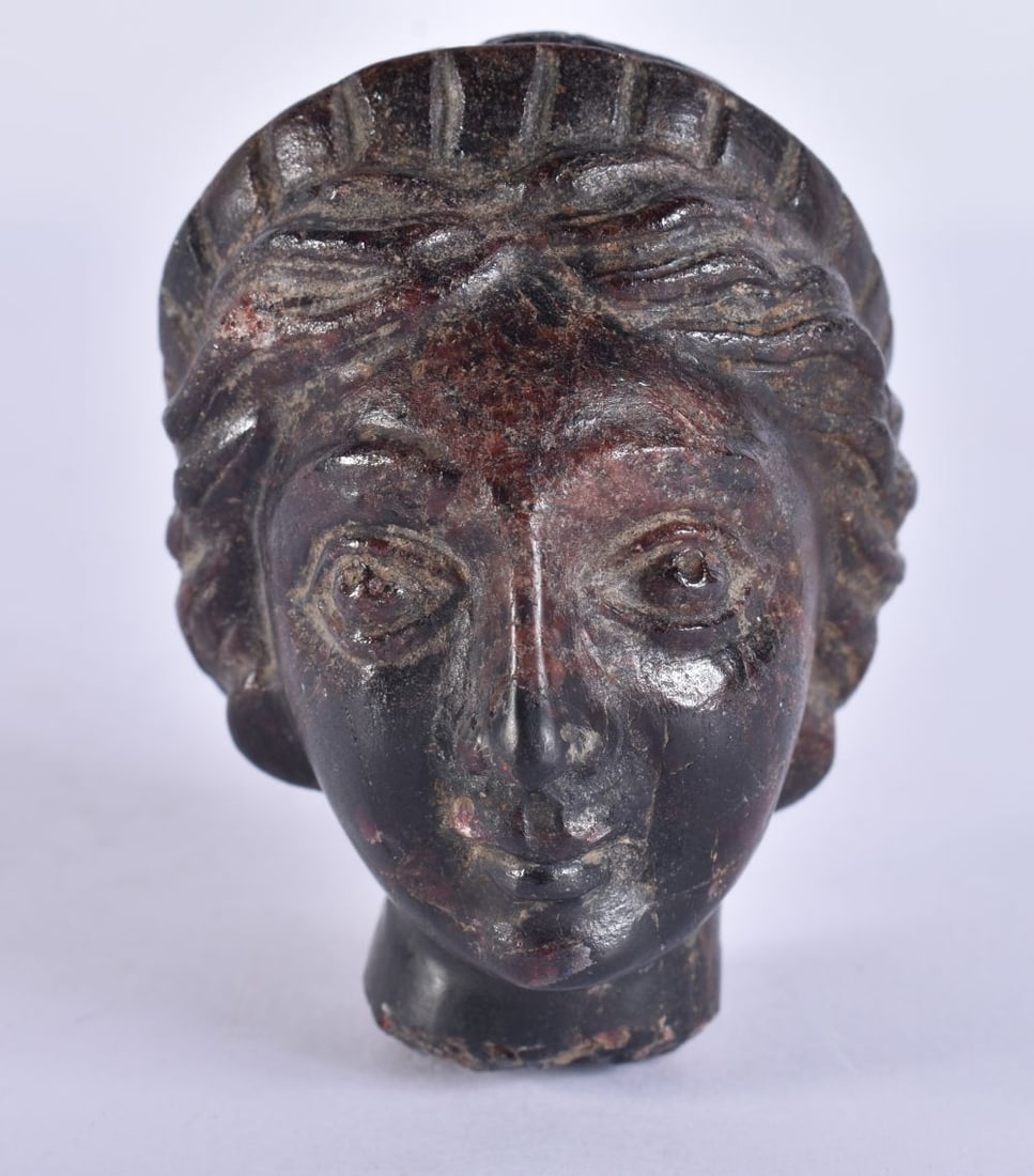 AN EARLY ANTIQUITY CARVED HARDSTONE HEAD with iridescent red specks, formed as a female. 7.5 cm x 6 (1 of 5)