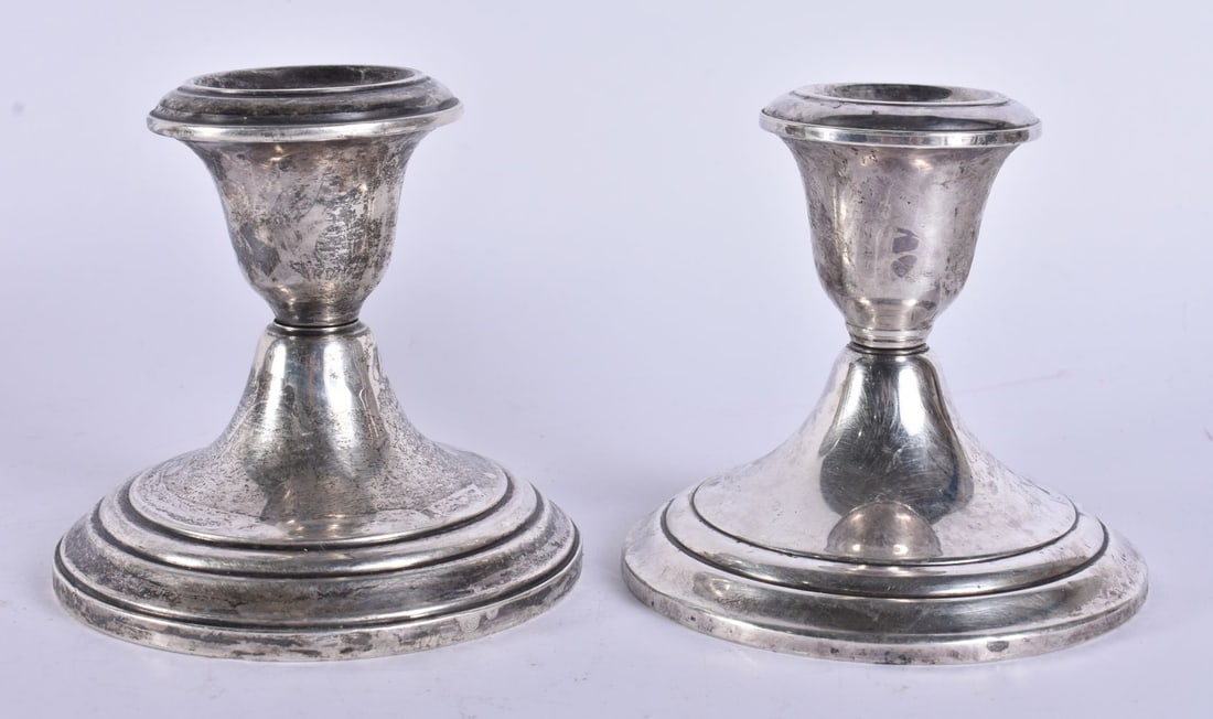 A PAIR OF SILVER CANDLESTICKS. 700 grams overall. 10 cm high. (1 of 5)