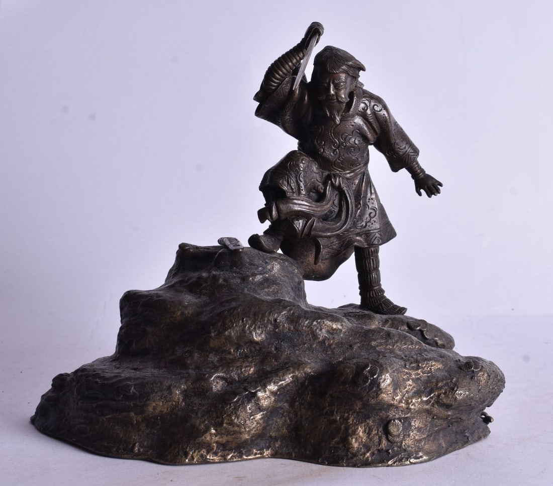 A 19TH CENTURY JAPANESE BRONZE OKIMONO OF A MALE modelled upon a rocky outcrop. 21 cm x 18 cm. (1 of 6)