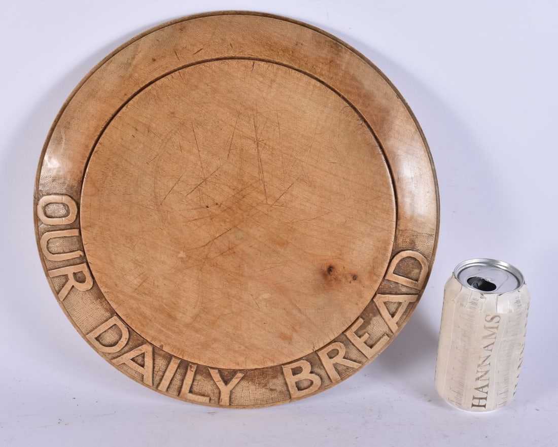 A TREEN WOOD BREAD BOARD. 30 cm diameter. (1 of 2)
