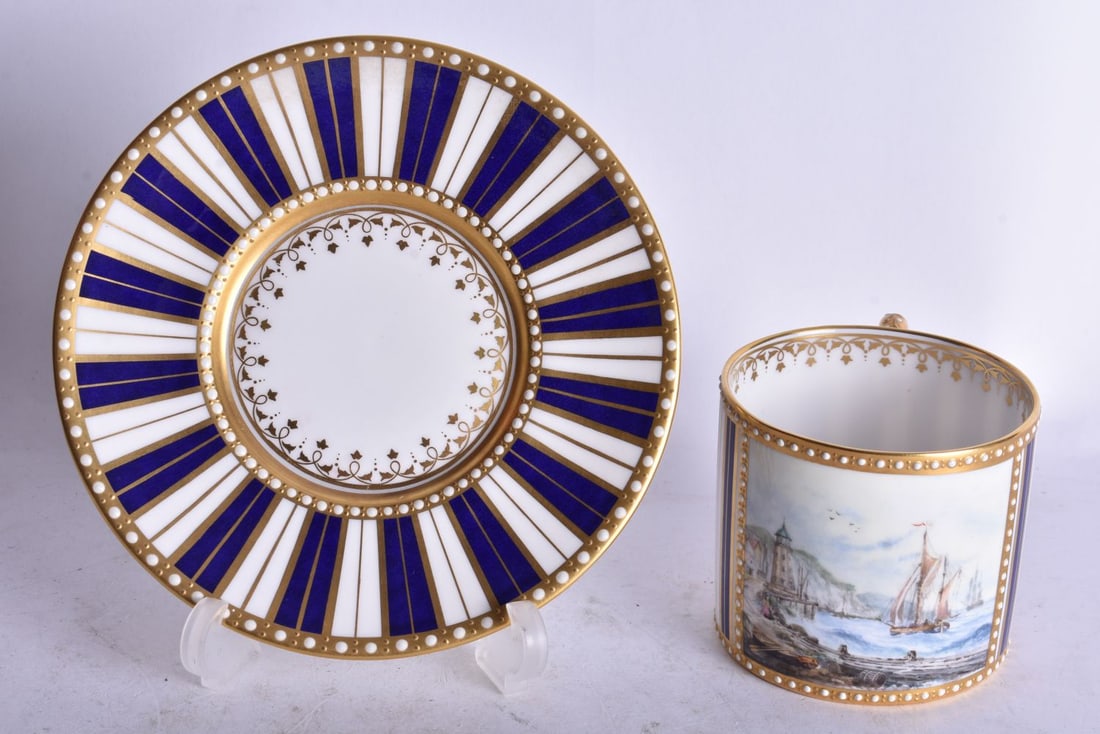 Stefan Nowacki (Derby) coffee can and saucer painted with a ship in in a harbour signed and monogram: Stefan Nowacki (Derby) coffee can and saucer painted with a ship in in a harbour signed and monogrammed c. 1970. Largest 13.5cm diameter