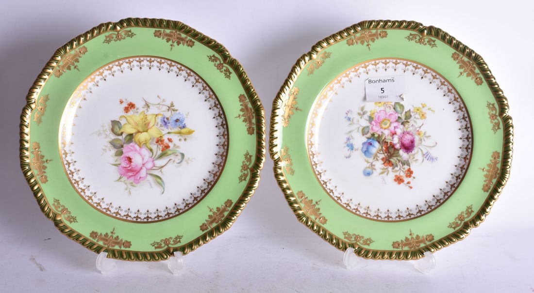 Royal Crown Derby pair of plates painted with two tone green borders, the centre finely painted by M (1 of 2)