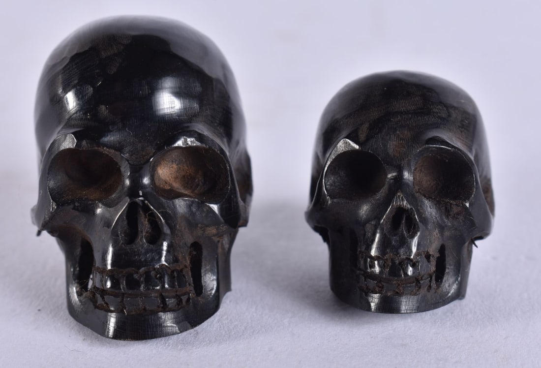 TWO MEMENTO MORI HORN SKULLS. 1.9 grams. 3.25 cm x 3 cm. (1 of 4)
