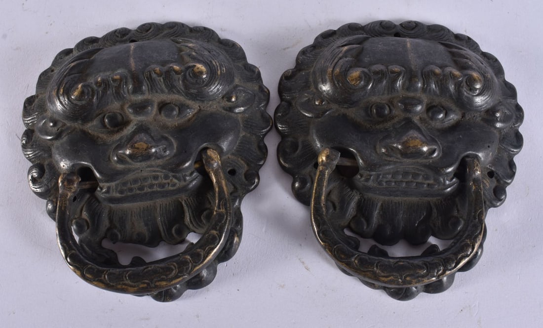 A PAIR OF TIBETAN MASK HEAD HANDLES. 10 cm x 11.25 cm. (1 of 3)
