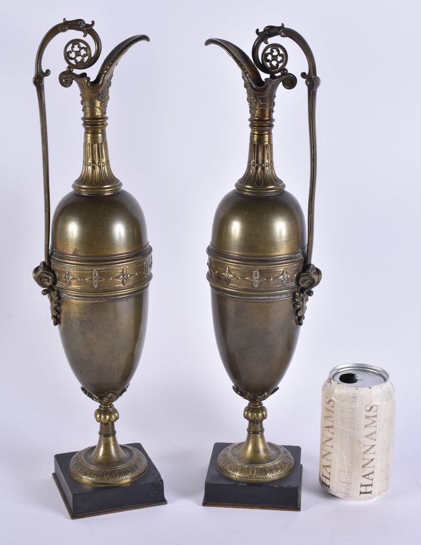A LARGE PAIR OF 19TH CENTURY EUROPEAN BRONZE GRAND TOUR EWERS modelled with mask heads, overlaid wit: A LARGE PAIR OF 19TH CENTURY EUROPEAN BRONZE GRAND TOUR EWERS modelled with mask heads, overlaid with motifs. 41 cm high.