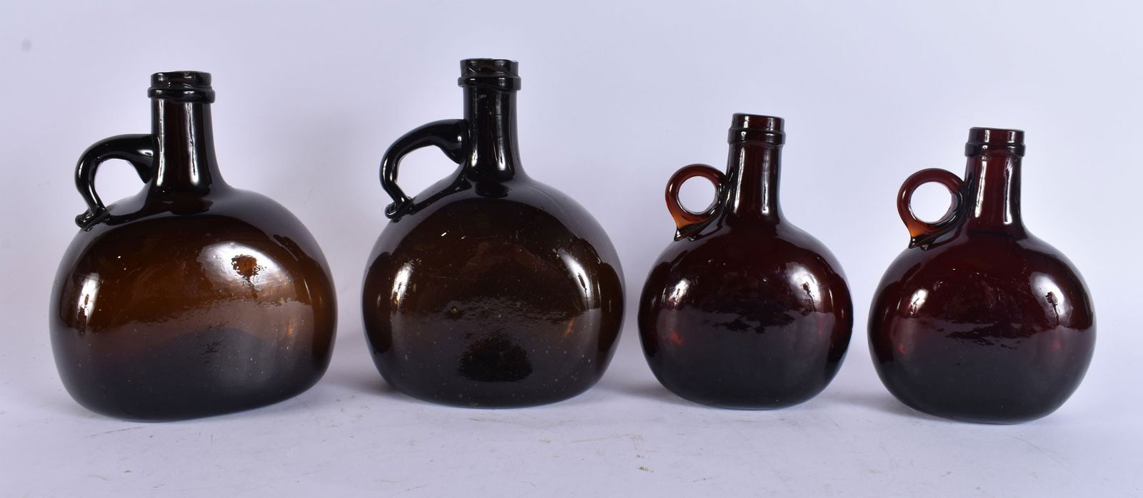 FOUR SMOKY GLASS WHISKEY BOTTLES. Largest 18 cm x 12 cm. (4): FOUR SMOKY GLASS WHISKEY BOTTLES. Largest 18 cm x 12 cm. (4)