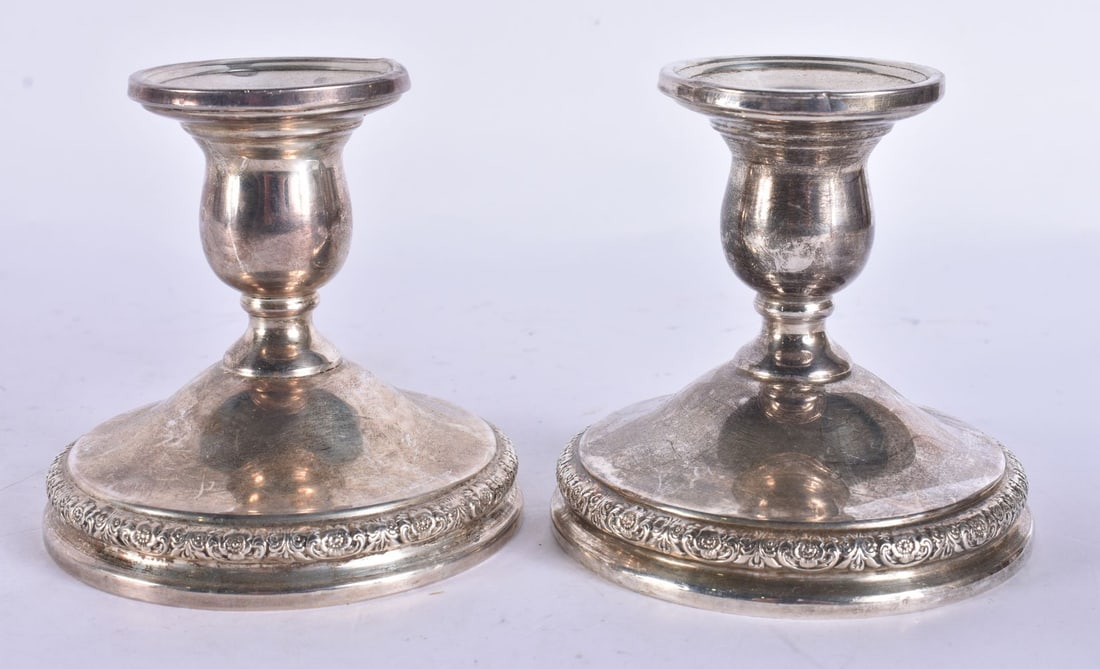 A PAIR OF SILVER CANDLESTICKS. 655 grams overall. 6 cm high. (1 of 5)