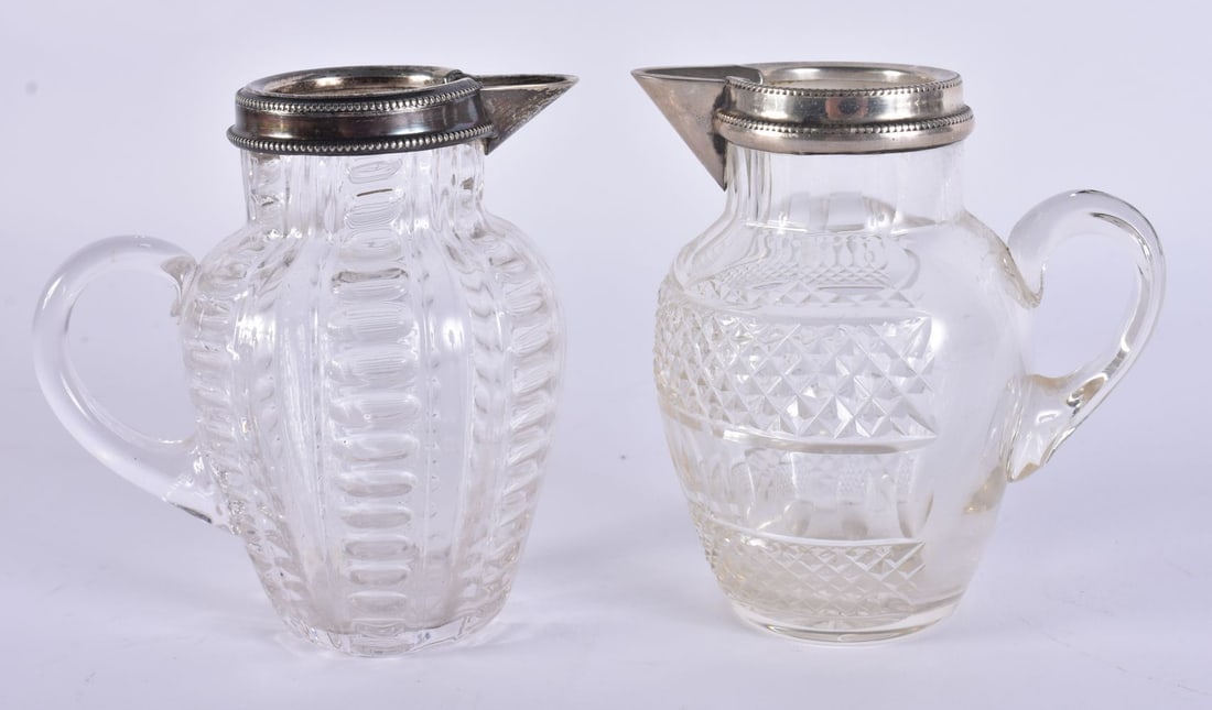 A PAIR OF SILVER MOUNTED JUGS. 10 cm high.: A PAIR OF SILVER MOUNTED JUGS. 10 cm high.