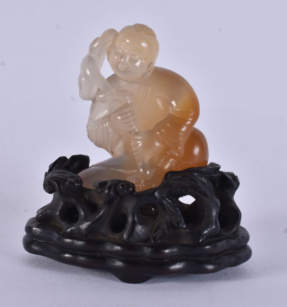 A FINE CHINESE QING DYNASTY CARVED AGATE FIGURE OF A BOY modelled upon a Zitan wood stand. 7 cm x 4. (1 of 9)