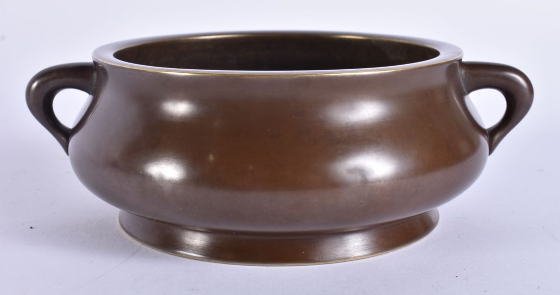 A CHINESE QING DYNASTY TWIN HANDLED BRONZE CENSER bearing Xuande marks to base. 15 cm wide, internal (1 of 5)