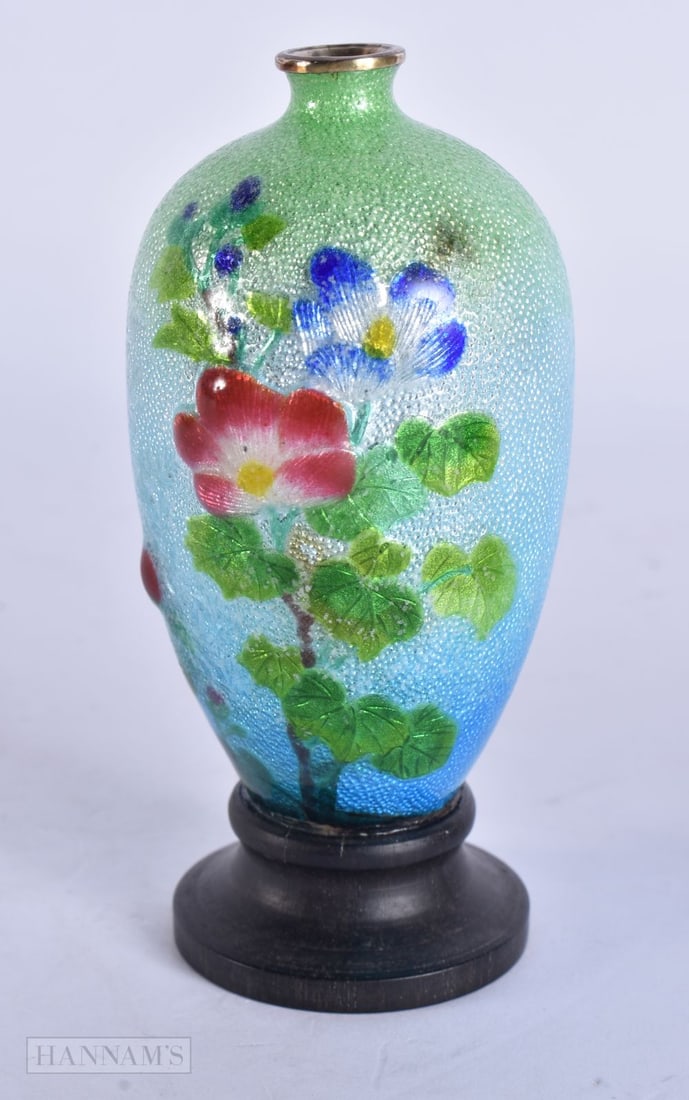 AN EARLY 20TH CENTURY JAPANESE MEIJI PERIOD SILVER BODY ENAMEL VASE decorated with flowers on a blue: AN EARLY 20TH CENTURY JAPANESE MEIJI PERIOD SILVER BODY ENAMEL VASE decorated with flowers on a blue and green ground. 11.5 cm high.