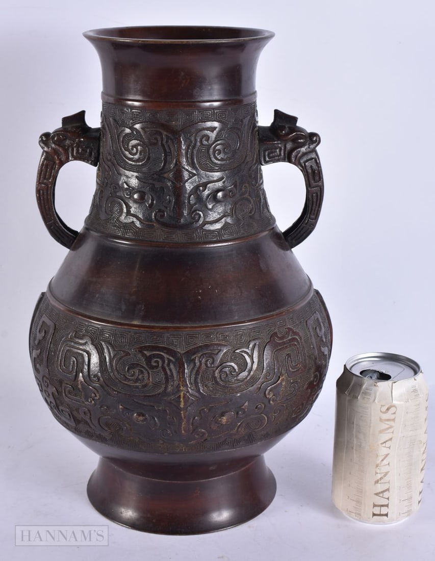 A LARGE CHINESE QING DYNASTY TWIN HANDLED BRONZE VASE decorated in relief with taotie mask heads. 35 (1 of 7)