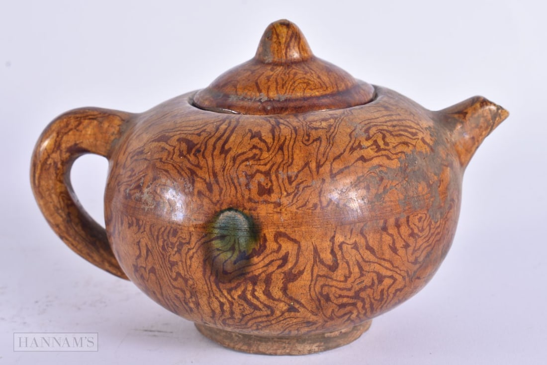 A CHINESE MARBLEISED POTTERY TEAPOT AND COVER. 14cm wide.: A CHINESE MARBLEISED POTTERY TEAPOT AND COVER. 14cm wide.