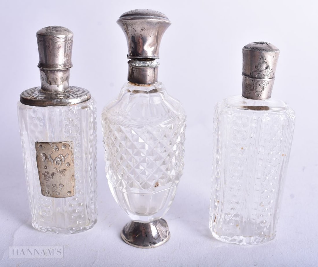 THREE SILVER MOUNTED CUT GLASS SCENT BOTTLES. 134 grams overall. 9.5 cm high. (3) (1 of 4)