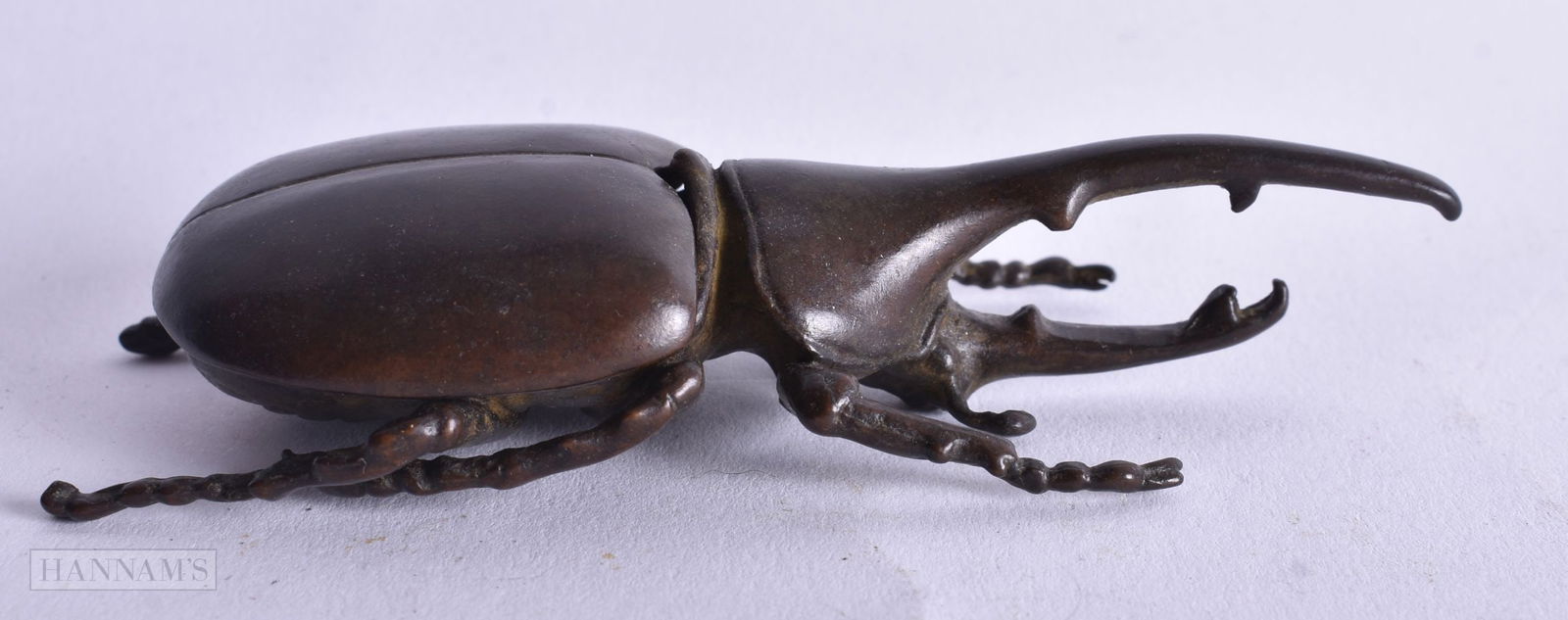 A Bronze Box and Cover in the form of a Rhinoceros Beetle. 10.2cm x 2.3cm x 4.3cm, weight 110g: A Bronze Box and Cover in the form of a Rhinoceros Beetle. 10.2cm x 2.3cm x 4.3cm, weight 110g