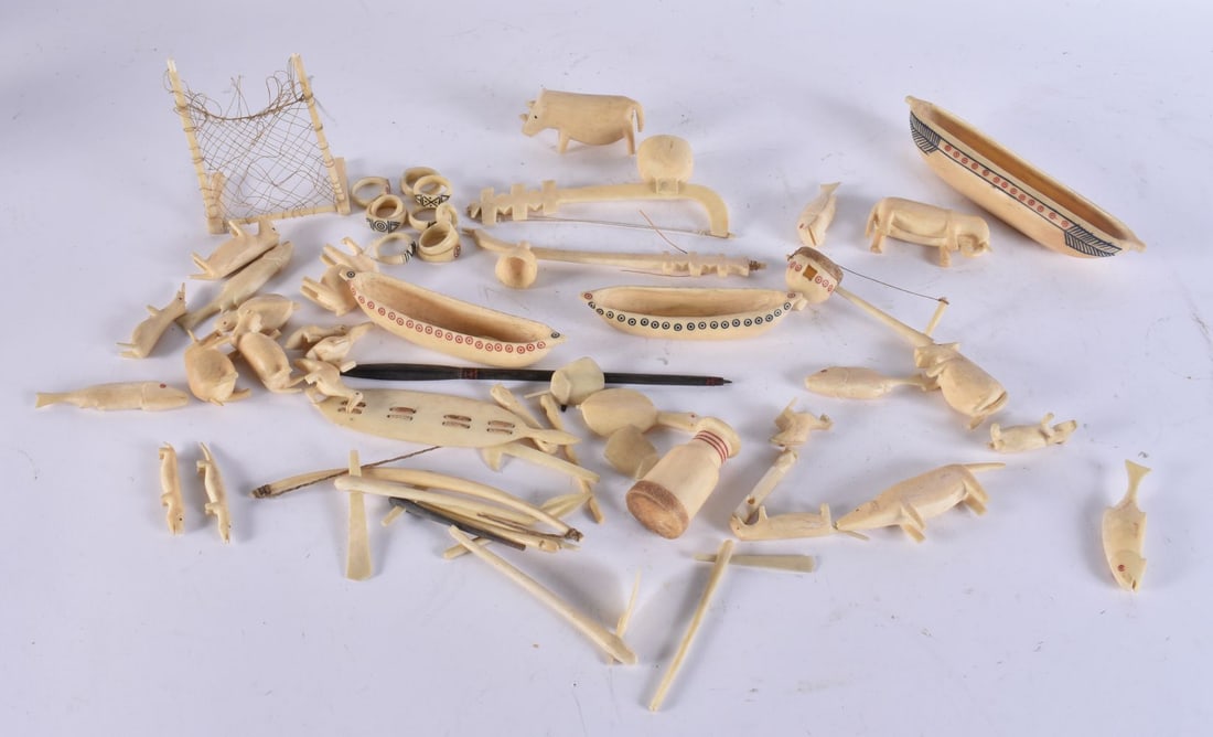 AN UNUSUAL COLLECTION OF ANTIQUE INUIT NORTH AMERICAN CARVED BONE ARTEFACTS including boats, animals (1 of 7)