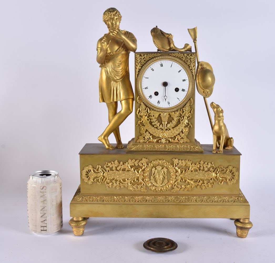 A LARGE MID 19TH CENTURY FRENCH EMPIRE ORMOLU CLOCK formed as a man and dog beside armour. 44 cm x 2: A LARGE MID 19TH CENTURY FRENCH EMPIRE ORMOLU CLOCK formed as a man and dog beside armour. 44 cm x 28 cm.