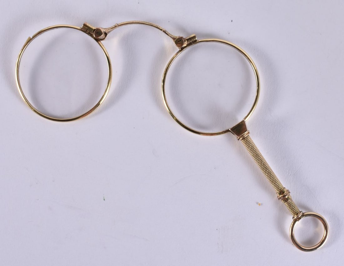 A PAIR OF YELLOW METAL LORGNETTES. 14 cm long extended. (1 of 2)