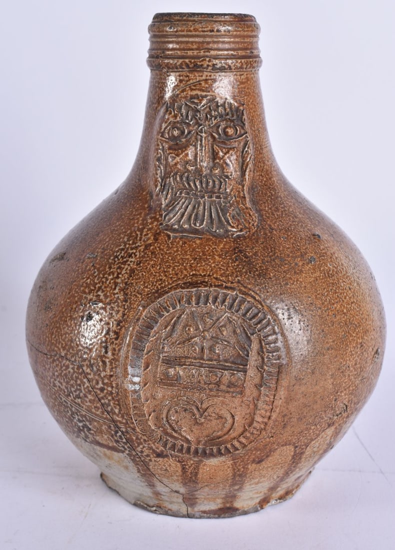 A 17TH/18TH CENTURY GERMAN SALT GLAZED BELLARMINE JUG bearing armorial to the front. 18 cm long. (1 of 5)