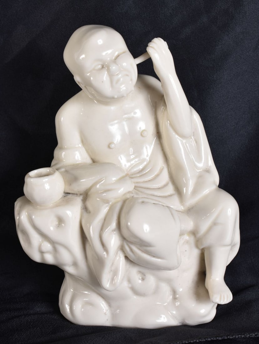 A LATE 19TH CENTURY CHINESE BLANC DE CHINE PORCELAIN FIGURE modelled as a male picking his ears. 15 (1 of 6)