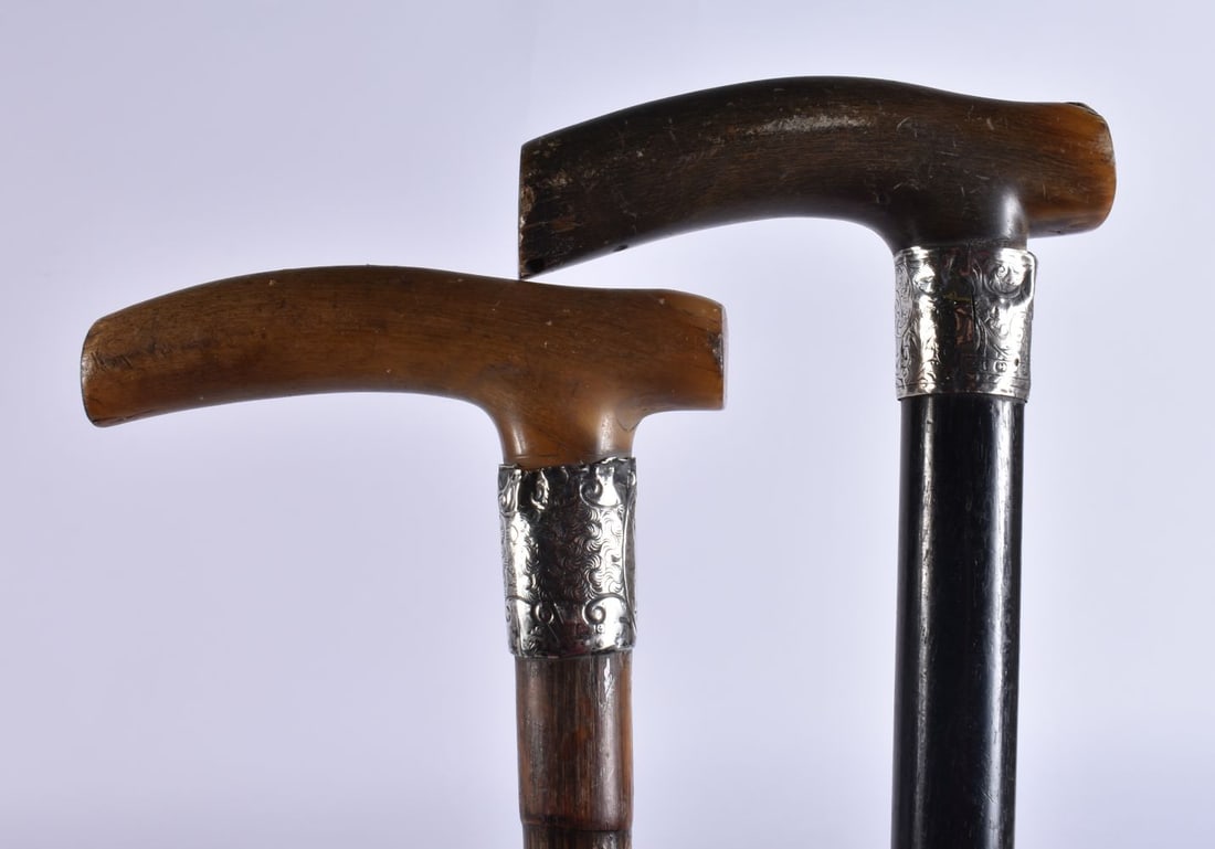 TWO ANTIQUE CARVED RHINOCEROS HORN HANDLED WALKING CANES with silver mounts. 90 cm long. (2) (1 of 3)