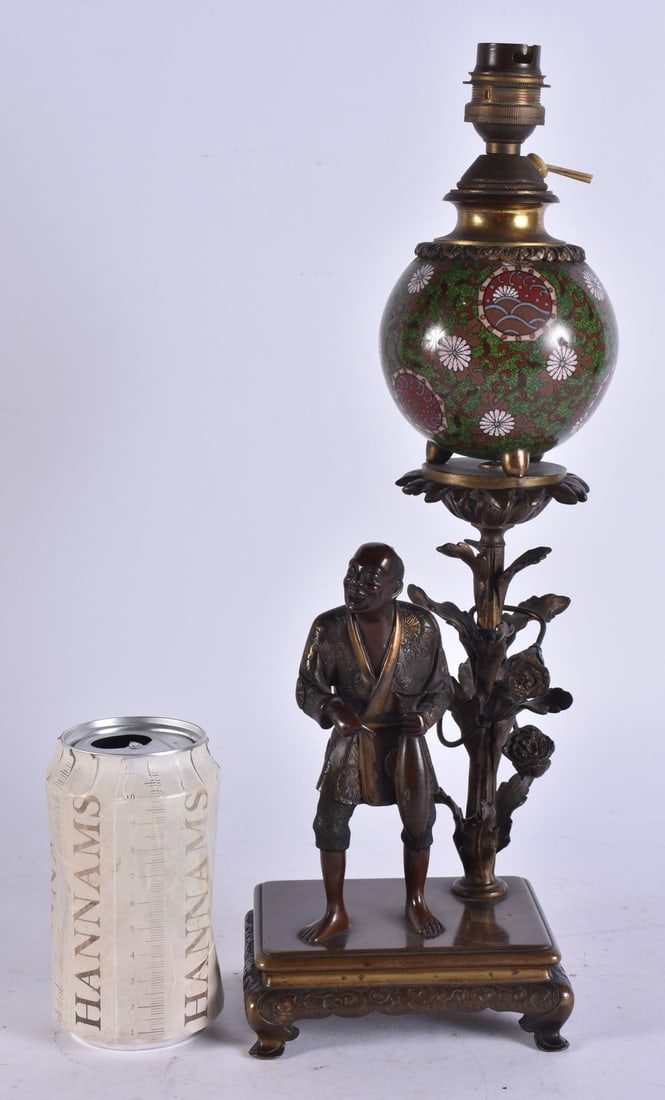 A 19TH CENTURY JAPANESE MEIJI PERIOD BRONZE AND CLOISONNE ENAMEL LAMP formed with a standing figure: A 19TH CENTURY JAPANESE MEIJI PERIOD BRONZE AND CLOISONNE ENAMEL LAMP formed with a standing figure holding a fish. 37 cm high.