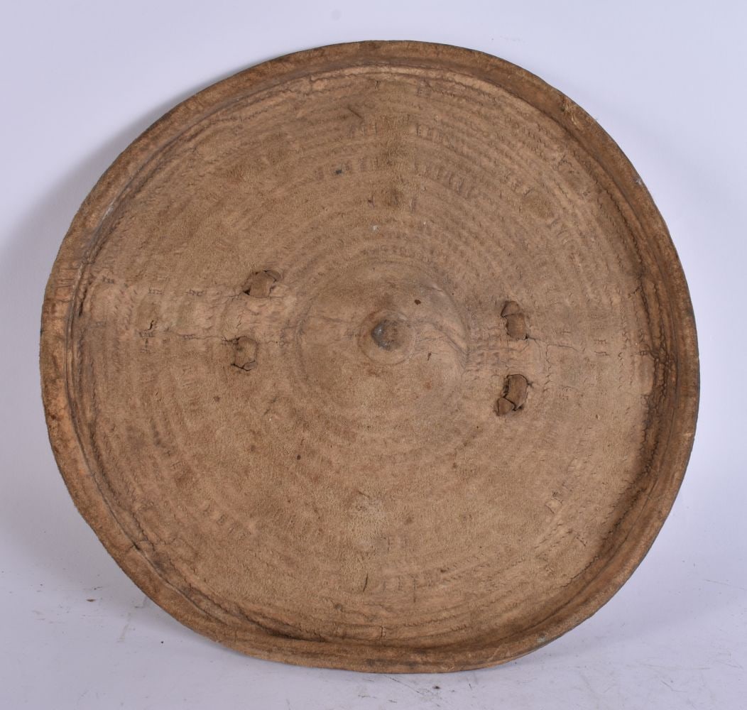 AN EARLY 20TH CENTURY OMANI AFRICAN RHINOCEROS SKIN BACKLER SHIELD. 31 cm wide.: AN EARLY 20TH CENTURY OMANI AFRICAN RHINOCEROS SKIN BACKLER SHIELD. 31 cm wide.