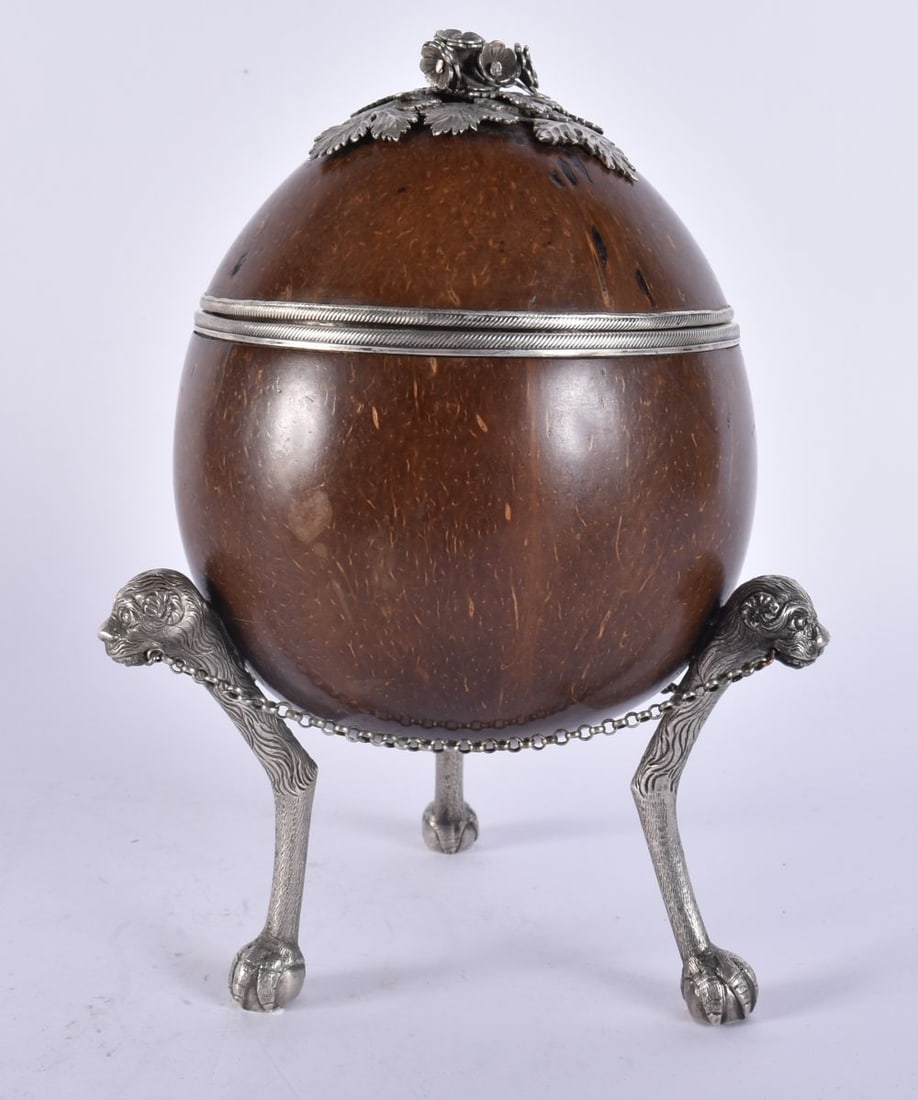 AN EARLY 19TH CENTURY CONTINENTAL SILVER MOUNTED COCONUT CADDY formed with animal feet and overlaid (1 of 7)