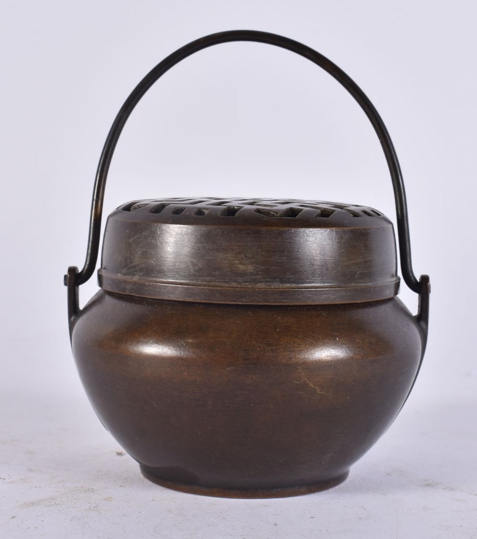 A CHINESE BRONZE SWING HANDLED CENSER. 11 cm high inc handle. (1 of 4)