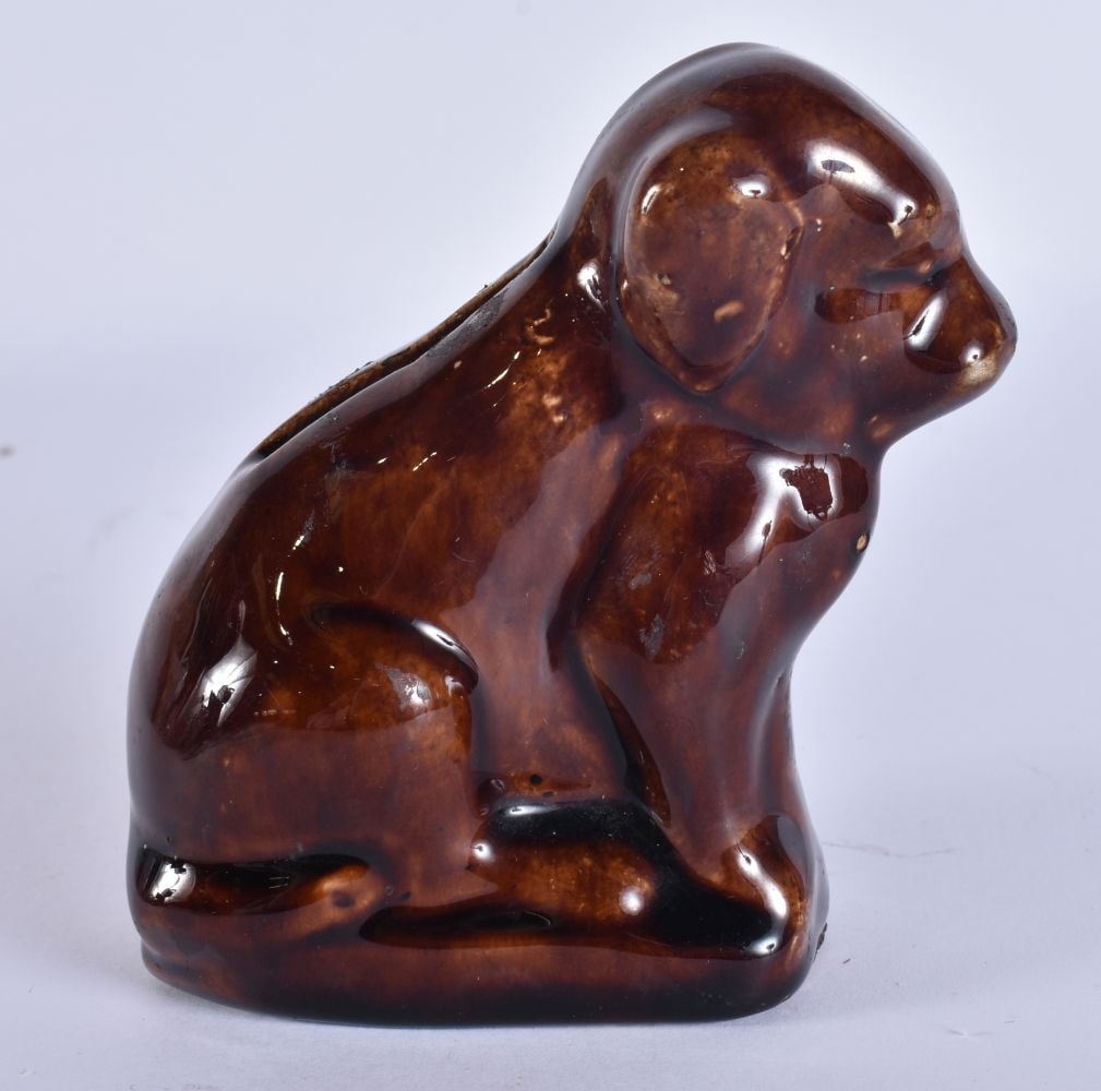 A TREACLE GLAZED POTTERY DOG MONEY BOX. 10 cm x 8 cm. (1 of 5)