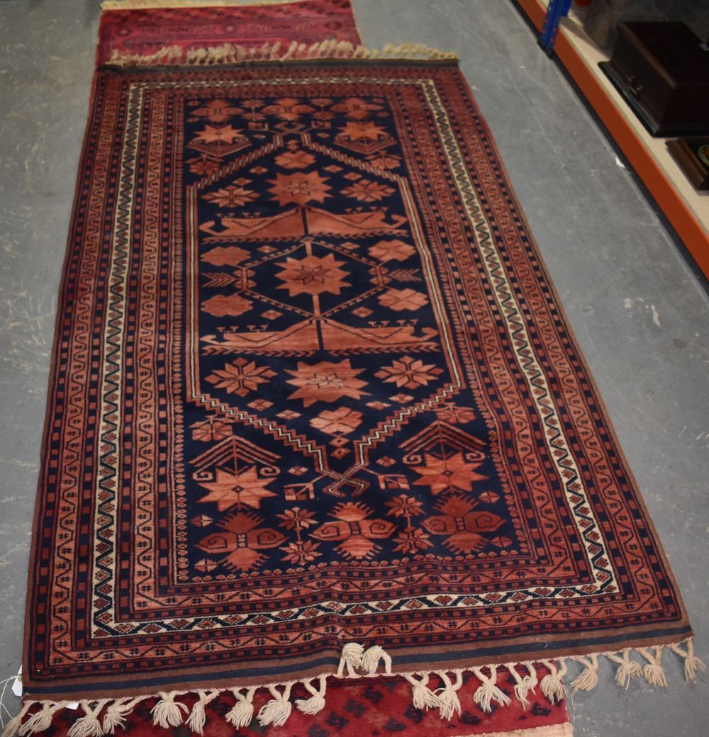 AN EASTERN RED AND BLUE GROUND RUG. 202 cm x 115 cm. (1 of 5)