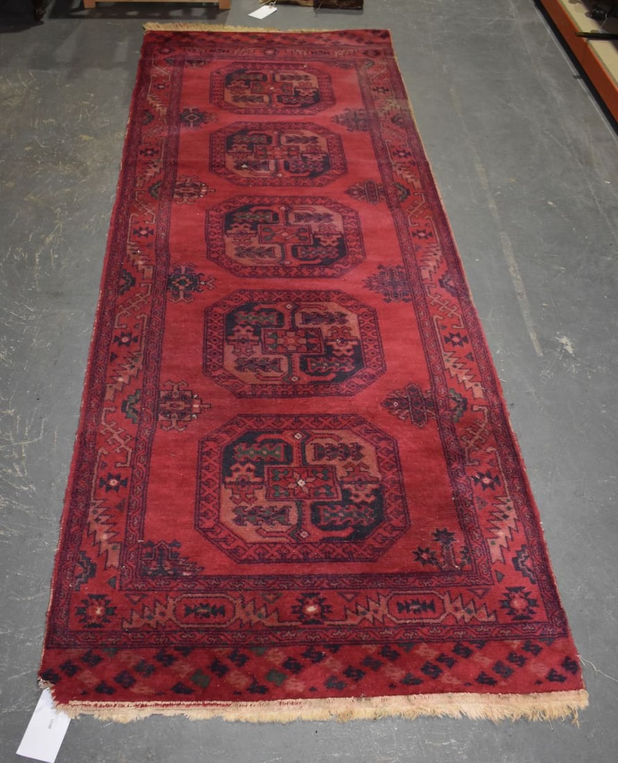 AN EASTERN RED GROUND RUG. 255 cm x 85 cm. (1 of 6)