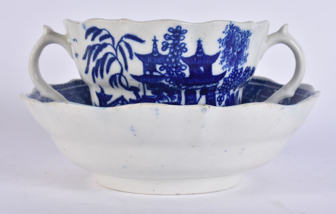 AN 18TH CENTURY WORCESTER TWIN HANDLED CHOCOLATE CUP AND SAUCER decorated with the Temple pattern. 1: AN 18TH CENTURY WORCESTER TWIN HANDLED CHOCOLATE CUP AND SAUCER decorated with the Temple pattern. 13 cm wide. (2)