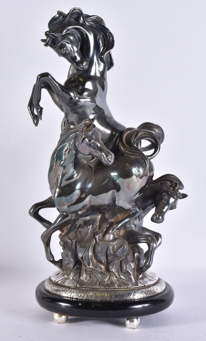 OTTAVIANI, ITALIAN 20TH CENTURY A SILVER FILLED EQUESTRIAN GROUP SIGNED AND STAMPED 925 ON AN EBONIS: OTTAVIANI, ITALIAN 20TH CENTURY A SILVER FILLED EQUESTRIAN GROUP SIGNED AND STAMPED 925 ON AN EBONISED BASE modelled as three spirited horses rearing on a rocky outcrop, the ebonised plinth with a tex