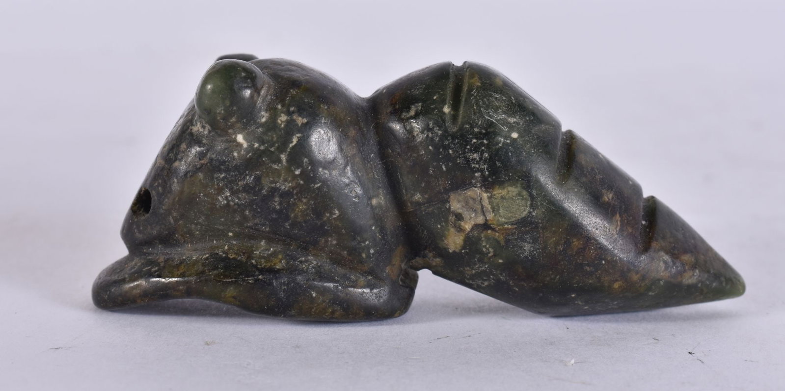 A CHINESE SPINACH JADE CARVING OF A SNAIL pierced for suspension carved in the round with a ridged c: A CHINESE SPINACH JADE CARVING OF A SNAIL pierced for suspension carved in the round with a ridged conical shell and extended head in a mottled dark green tone. 7.5 cm wide.