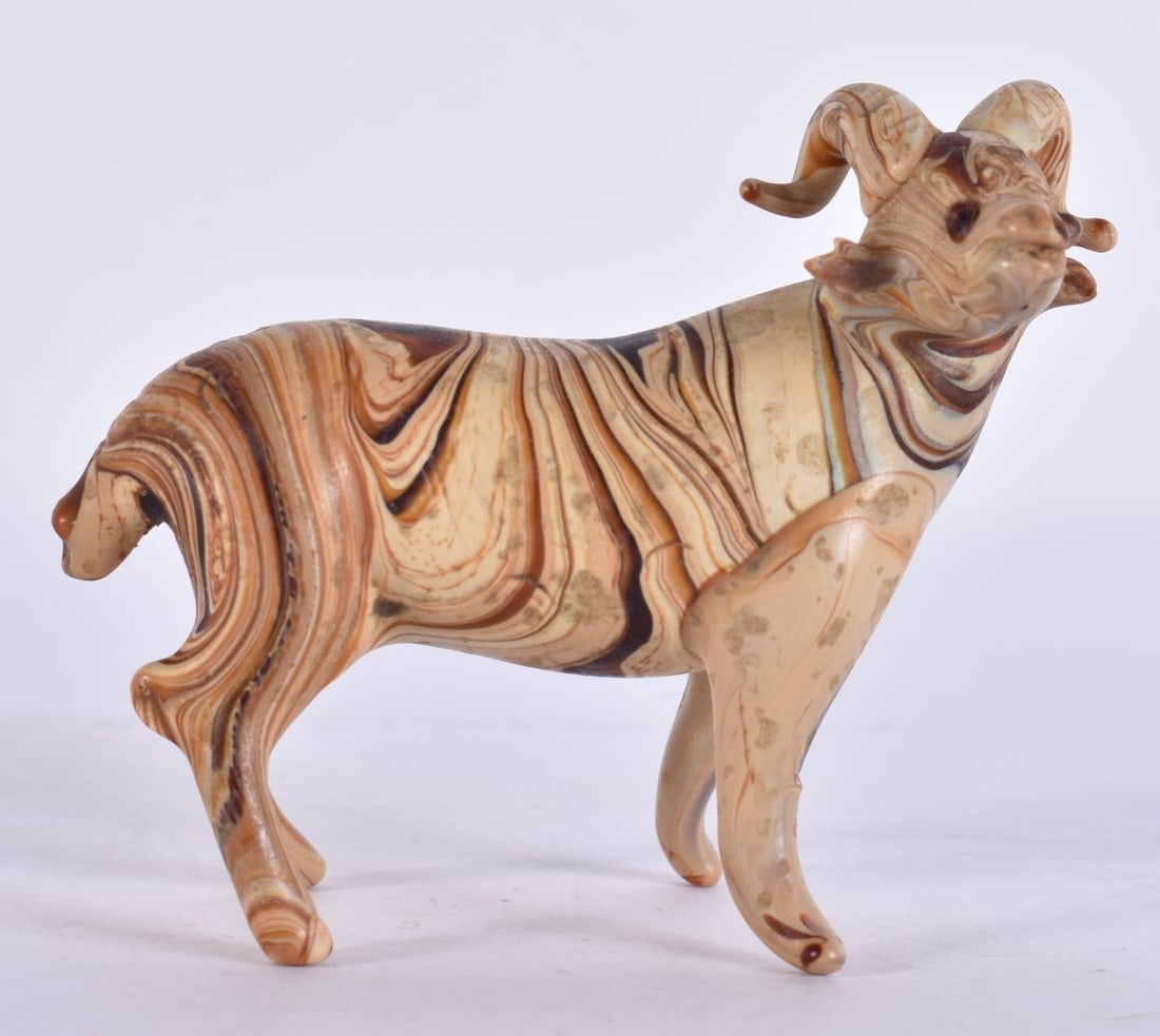 A 19TH CENTURY GLASS RAM modelled standing with curled horns and short tail, in marbled amber and cr (1 of 4)