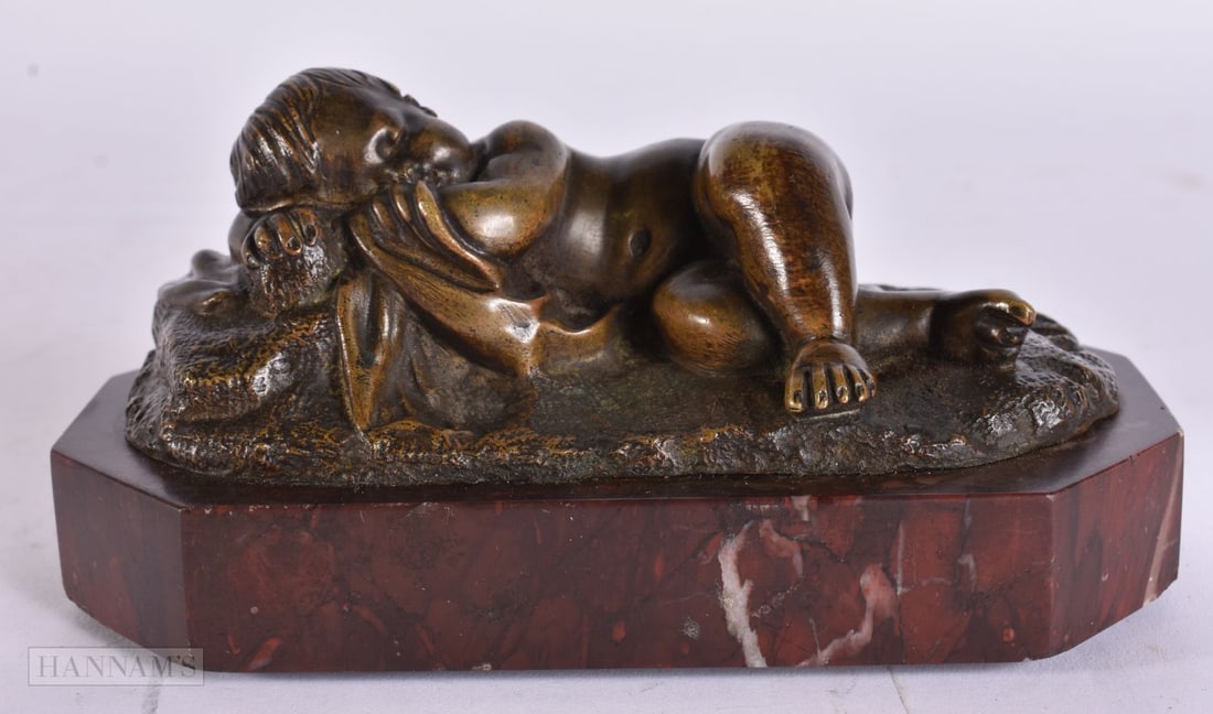 A MID 19TH CENTURY FRENCH BRONZE FIGURE OF A RECLINING BOY upon a red marble base. 14 cm wide. (1 of 6)