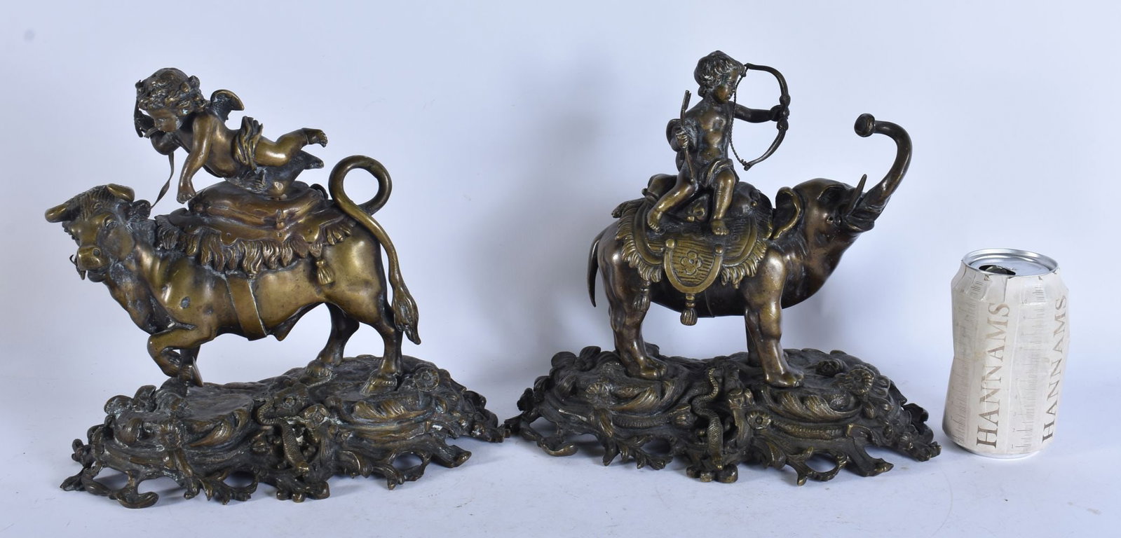 A PAIR OF 19TH CENTURY FRENCH BRONZE FIGURES modelled as roaming bulls with putti. 25 cm x 18 cm. (1 of 8)