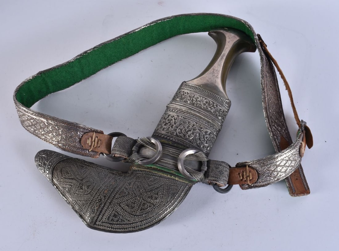 A MIDDLE EASTERN OMANI WHITE METAL CASED JAMBIYA DAGGER. Dagger 32 cm long. We are UNABLE to offer (1 of 2)