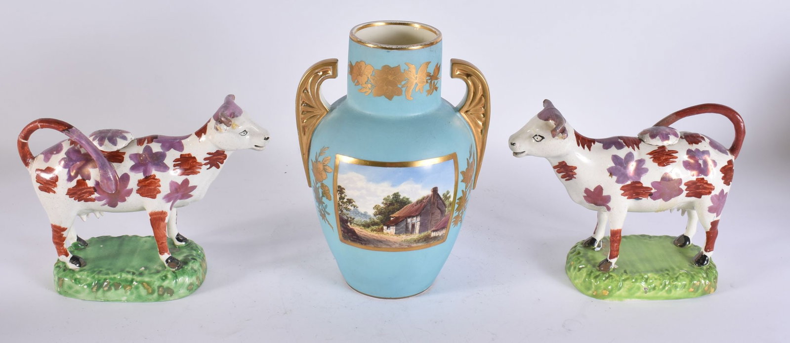 A PAIR OF VICTORIAN STAFFORDSHIRE LUSTRE COW CREAMERS and a vase. (3) (1 of 5)