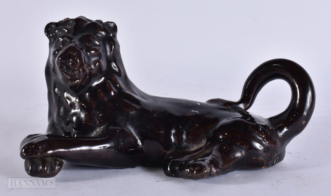 AN EARLY 19TH CENTURY TREACLE GLAZED LION. 15 cm wide. (1 of 3)