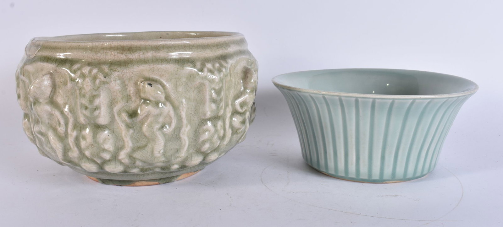 A 19TH CENTURY SOUTH EAST ASIAN RELIEF DECORATED BUDDHIST BOWL together with a flared celadon bowl. (1 of 4)