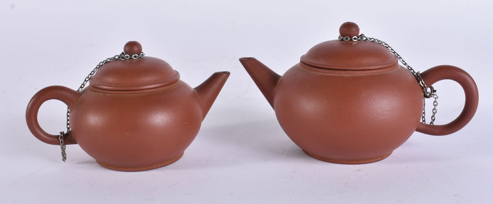 TWO EARLY 20TH CENTURY CHINESE YIXING POTTERY TEAPOTS AND COVERS Late Qing. Largest 10 cm wide. (2) (1 of 7)