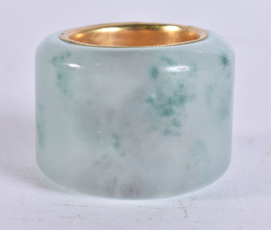 A CHINESE CARVED ICEY JADEITE ARCHERS RING. 3.5 cm wide. (1 of 3)