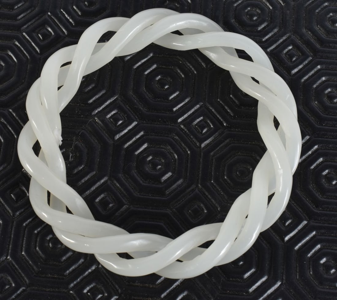 A CHINESE WHITE JADE TWIST BANGLE. 8.5 cm wide. (1 of 3)
